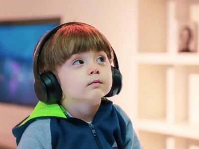 Little boy with special needs using headphones staring upwards