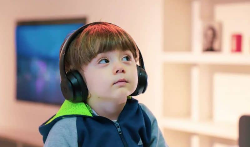 Little boy with special needs using headphones staring upwards