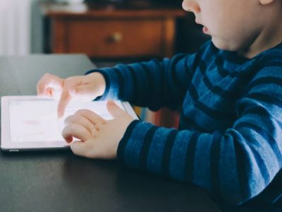 Young boy learning to use an iPad