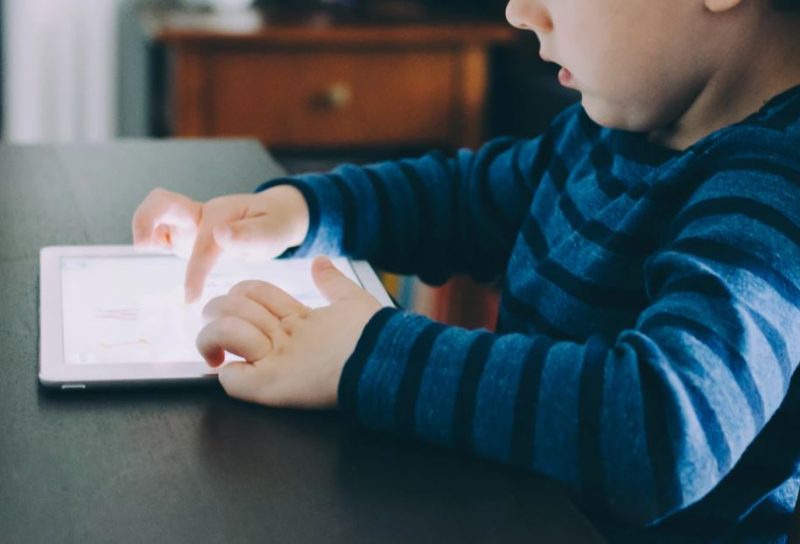 Young boy learning to use an iPad