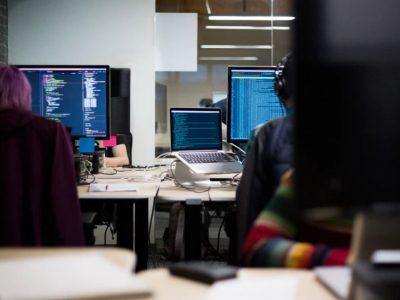 People sitting at computers doing online training and coding