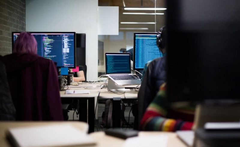 People sitting at computers doing online training and coding