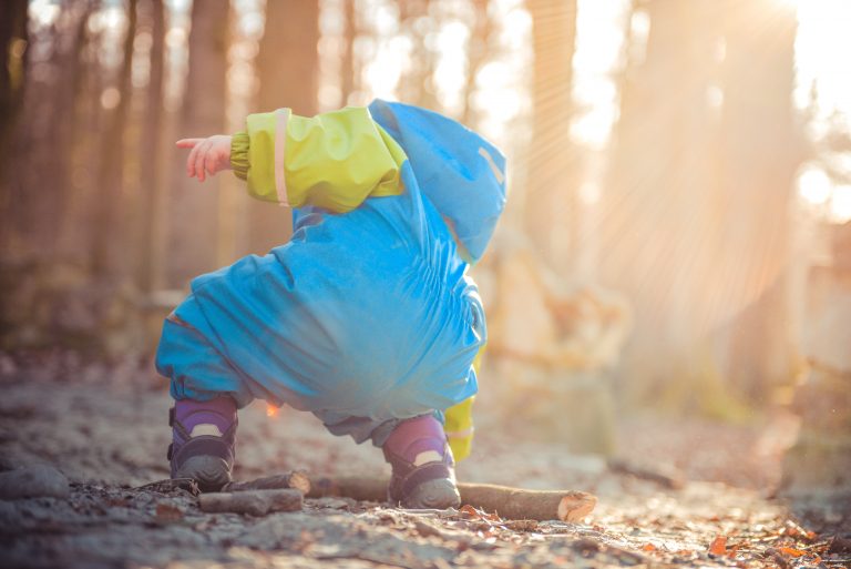 Toddler playing in the woods