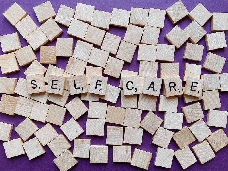 Scrabble tiles spelling out "self care""