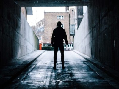 a shadowy figure standing in an underpass