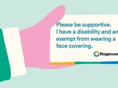 an illustration of a hard holding a card. The card says "please be supportive. I have a disability and am exempt from wearing a face covering"