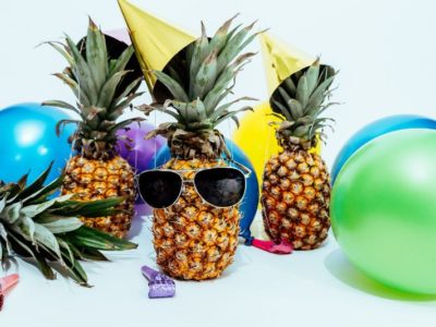 three pineapples surrounded by balloons