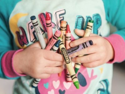 a child carrying crayons