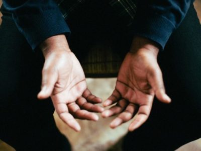 a person opening their hands upward in prayer