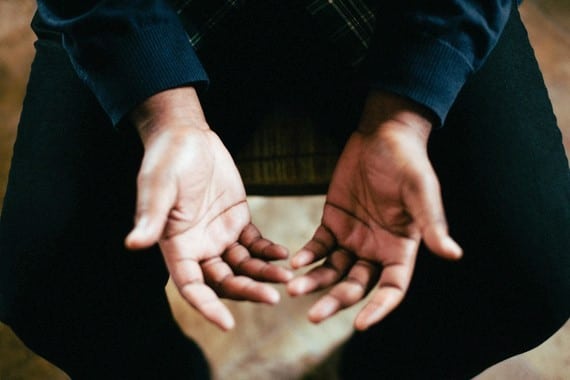 a person opening their hands upward in prayer