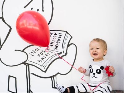 a small child holding a red balloon