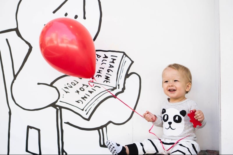 a small child holding a red balloon