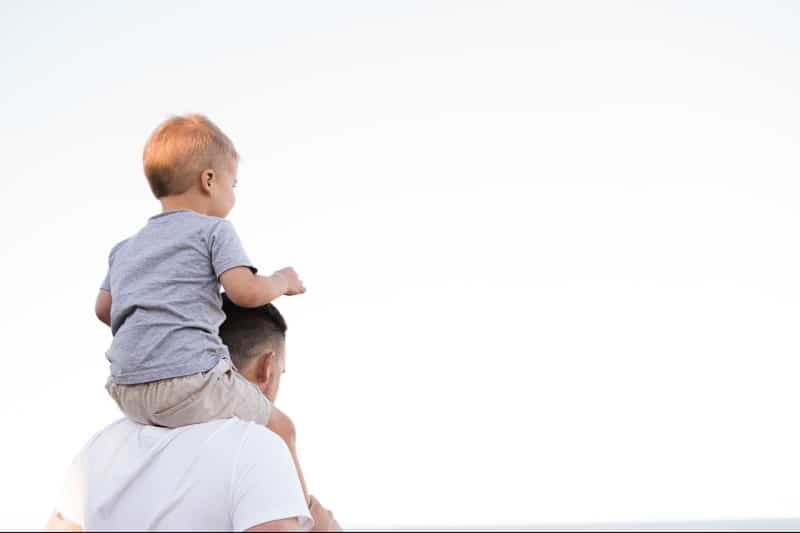 a man carrying a child on his shoulders