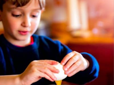 a boy cracking an egg