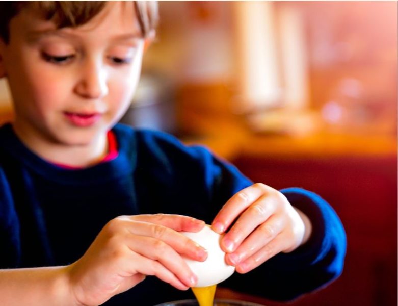 a boy cracking an egg