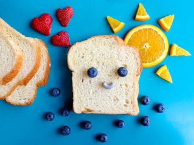 a slice of bread with a smiley face made out of blueberries