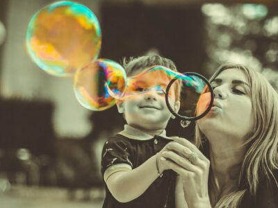 a mother and child blowing bubbles