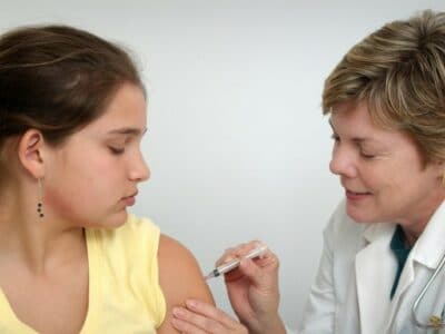 a girl being vaccinated by a doctor