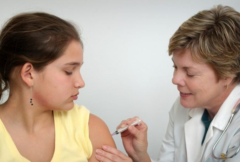 a girl being vaccinated by a doctor