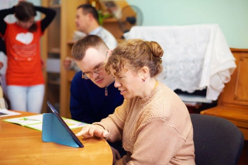 two friends with disability watching digital tablet