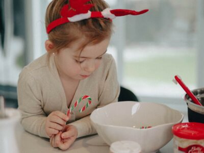 a girl wearing Christmas antlers doing some baking