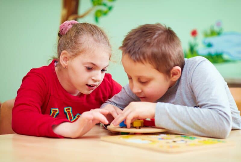 Children playing with a wooden toy