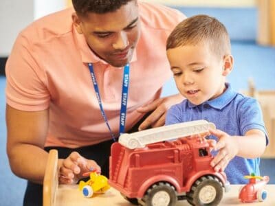 Man and child playing with truck