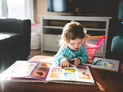 a photo of a toddler reading a book